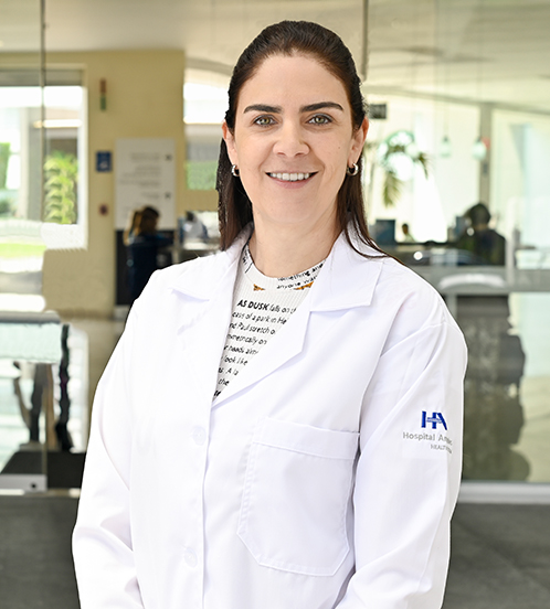 Es la foto de perfil de una internista en Ciudad de México de Hospital Angeles. Tiene una bata blanca, una blusa con encaje azul, es de tez blanca, ojos azules, cabello negro y cejas pobladas.