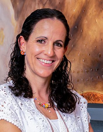 Es la foto de perfil de un nutriólogo en León de Hospital Angeles León. Utiliza una blusa de encaje blanco. Su cabello es negro y ondulado. Lleva un collar de colores.