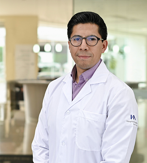 Especialista en Cardiología del Hospital Angeles Acoxpa Ciudad de México. Usa una bata blanca y camisa morada. Tiene el cabello negro y sonrie levemante.