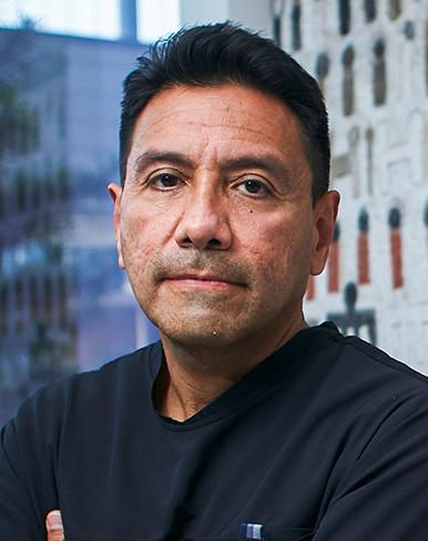 Es la foto de perfil de un neumólogo en Ciudad de México de Hospital Angeles Lindavista. Tiene el cabello negro. Usa un uniforme médico negro. Tiene los brazos cruzados.