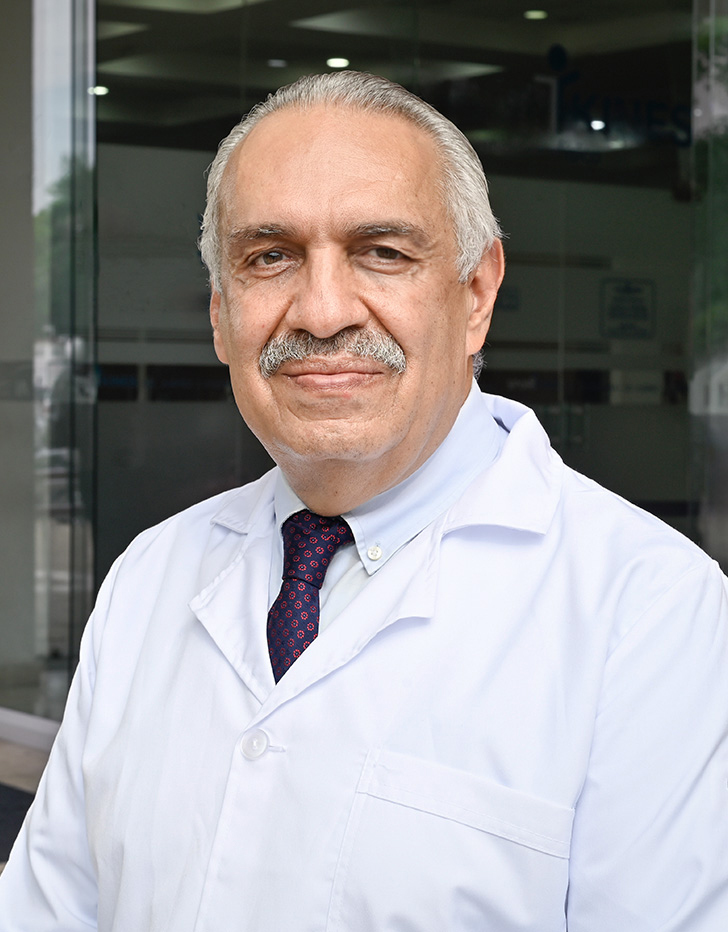 Es la foto de perfil de un otorrinolaringólogo en Villahermosa de Hospital Angeles Villahermosa. Usa una bata blanca con una camisa blanca y una corbata café. Tiene el cabello y bigote blanco. Está sonriendo ligeramente.