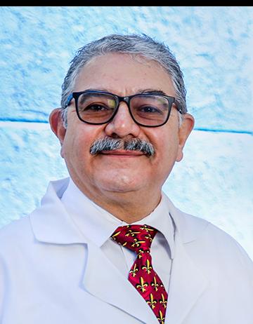 Es la foto de perfil de un urólogo en León de Hospital Angeles León. Tiene bigote y usa lentes color negro, junto con una corbata roja.