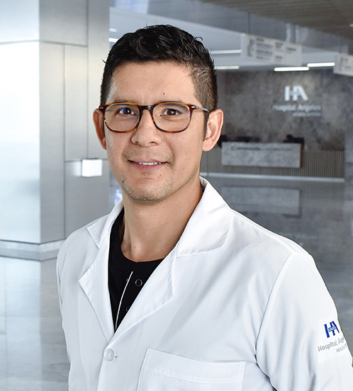 Es la foto de perfil de un médico en medicina crítica en Querétaro de Hospital Angeles Centro-sur.Usa una batacon un uniforme médico color negro. Tiene el cabello negro, usa lentes y está sonriendo ligeramente.
