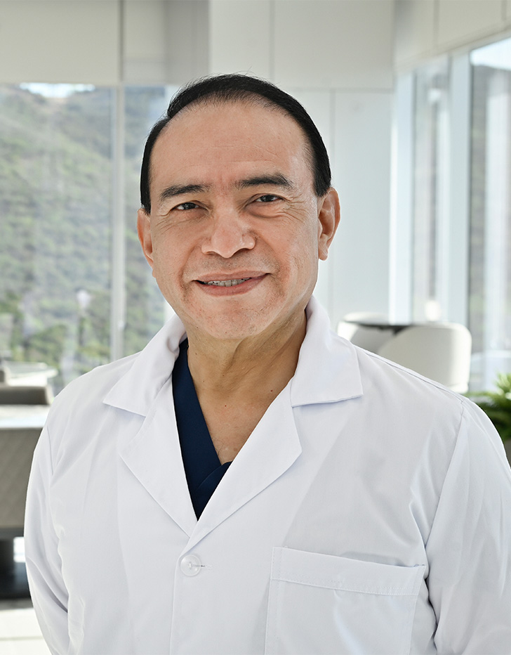 Es la foto de perfil de un pediatra y neonatólogo en San Pedro Garza de Hospital Angeles Valle Oriente. Usa una bata blanca con un uniforme médico azul marino. Tiene el cabello negro. Está sonriendo ligeramente.