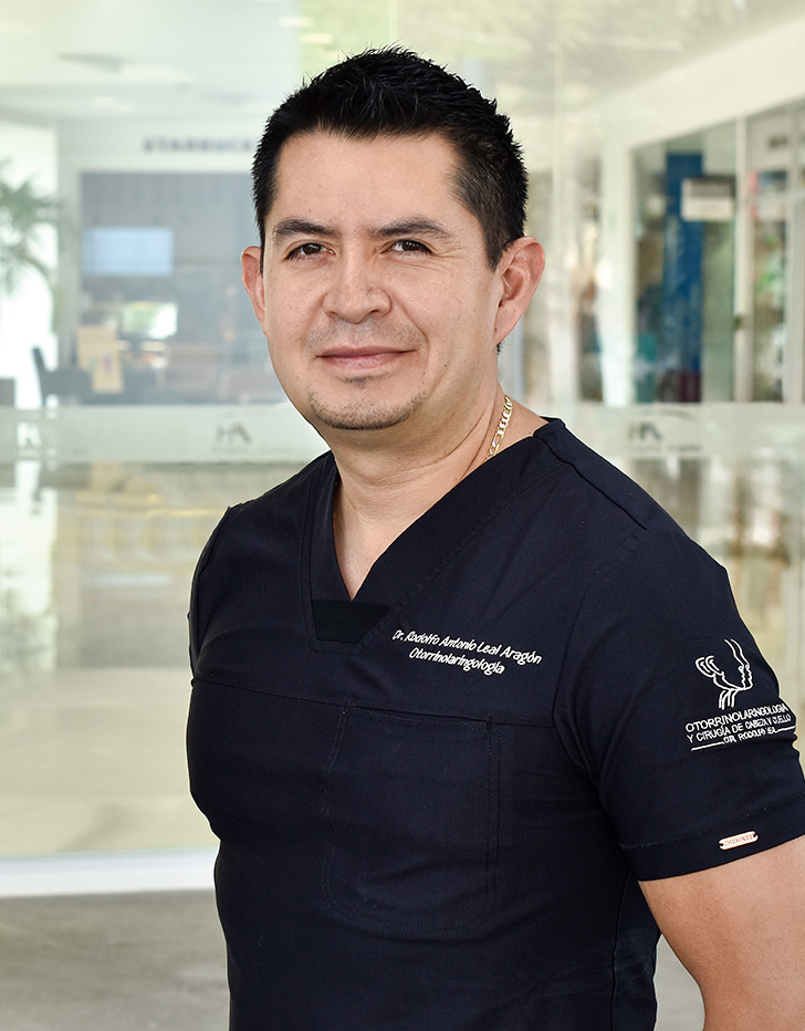 Es la foto de perfil de un otorrinolaringólogo en Ciudad de México de Hospital Angeles. Usa un uniforme azul, es de tez morena y cabello oscuro.