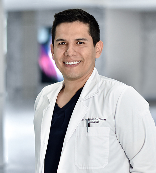 Es la foto de perfil de un cirujano general en Querétaro de Hospital Angeles Centro Sur. Usa una bata blanca con una playera negra debajo, tiene el cabello oscuro y está sonriendo.