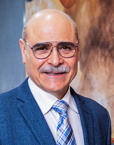 Es la foto de perfil de un ginecólogo y obstetra en León de Hospital Angeles León. Usa lentes, un saco color azul fuerte y una corbata de cuadros.