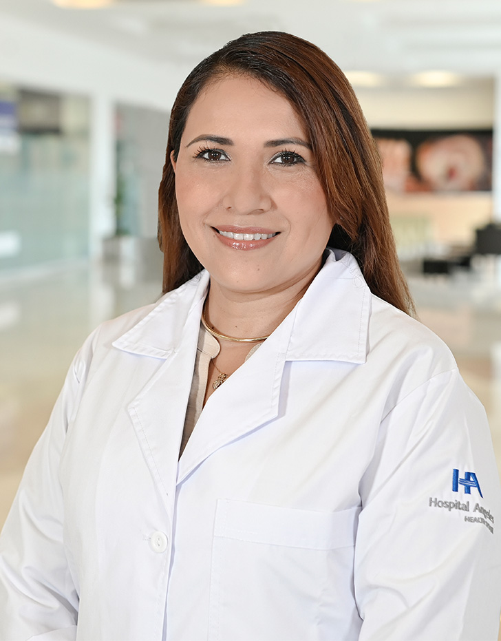 Es la foto de perfil de una pediatra, neumóloga pediátrica y especialista en broncospía en Xalapa de Hospital Angeles Xalapa. Usa una bata blanca con un uniforme médico azul. Tiene el cabello largo y café oscuro. Está sonriendo.