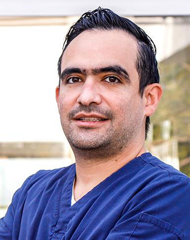 Es la foto de perfil de un urólogo en Guadalajara de Hospital Angeles Del Carmen. Utiliza un uniforme azul marino., tiene cejas pobladas y cabello oscuro.