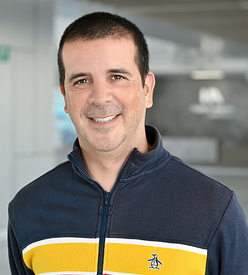 Es la foto de perfil de un hematólogo en Querétaro de Hospital Angeles Centro Sur. Usa una chamarra azul marino con franjas de colores, está sonriendo.