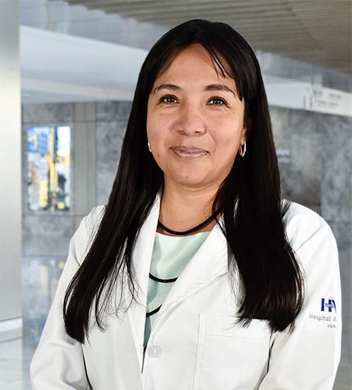 Es la foto de perfil de una cirujana general en Querétaro de Hospital Angeles Centro-sur. Usa una bata blanca con una blusa color menta con un collar largo color negro. Tiene el cabello lacio y de color negro. También tiene fleco.