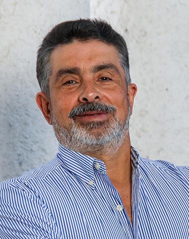 Es la foto de perfil de un ortopedista y traumatólogo en León de Hospital Angeles León. Tiene el cabello negro y una barba y bigote gris. Usa una camisa de cuadros blanco con azul.