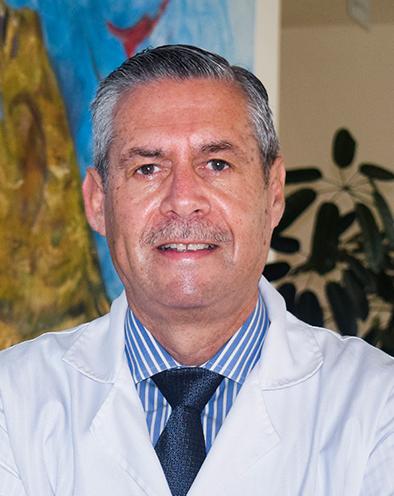 Es la foto de perfil de un gastroenterólogo y endoscopista en Xalapa de Hospital Angeles Xalapa. Usa una bata blanca, con una camisa azul de cuadros y una corbata azul marino. Tiene el cabello gris.