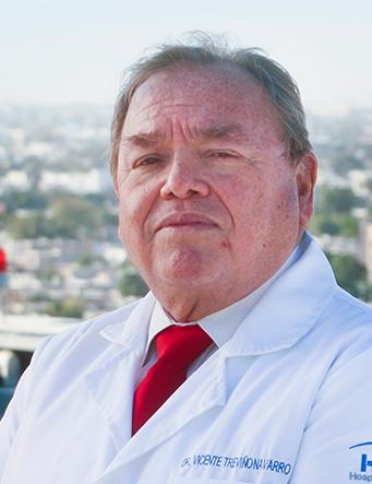 Es la foto de perfil de un ortopedista y traumatólogo en Torreón de Hospital Angeles Torreón. Usa una bata blanca con una camisa blanca y corbata blanca. Tiene el cabello gris.