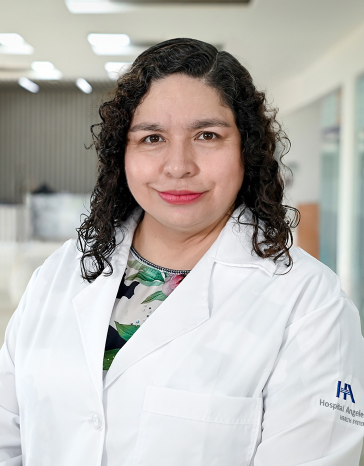 Es la foto de perfil de una ginecóloga y obstetra en Tampico de Hospital Angeles Tampico. Usa una bata blanca con una blusa negra. Tiene el cabello corto, chino y café oscuro. Usa un labial rogo.