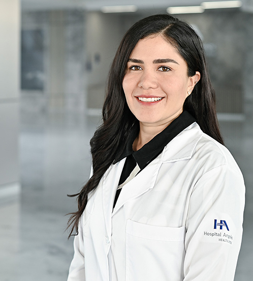 Es la foto de perfil de una algóloga en Querétaro de Hospital Angeles Centro-sur. Usa una bata color blanco. Tiene el cabello suelto y ondulado color café oscuro. Está sonriendo levemente.