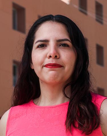 Es la foto de perfil de una coloproctóloga y cirujana general en Torreón de Hospital Angeles Torreón. Usa una blusa rosa. Tiene el cabello largo, lacio y negro. Usa unlabial rojo. Está sonriendo parcialmente.